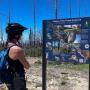 Checking out the Habitats of San Vicente Redwoods interp panel. Photo by Bridget Lyons.