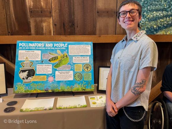 Undergrad Nefret Allen-Cantu and their “Pollinators and People” poster table. Photo by Bridget Lyons.
